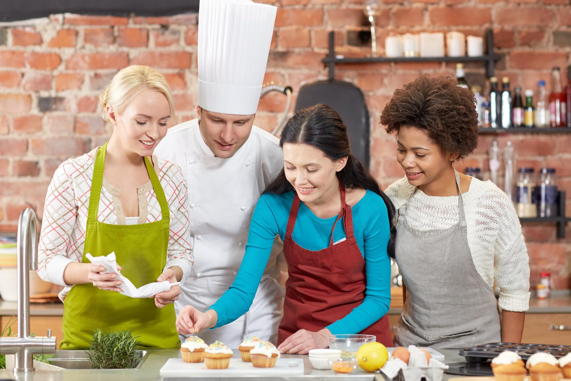 Bright training kitchen with students around a counter