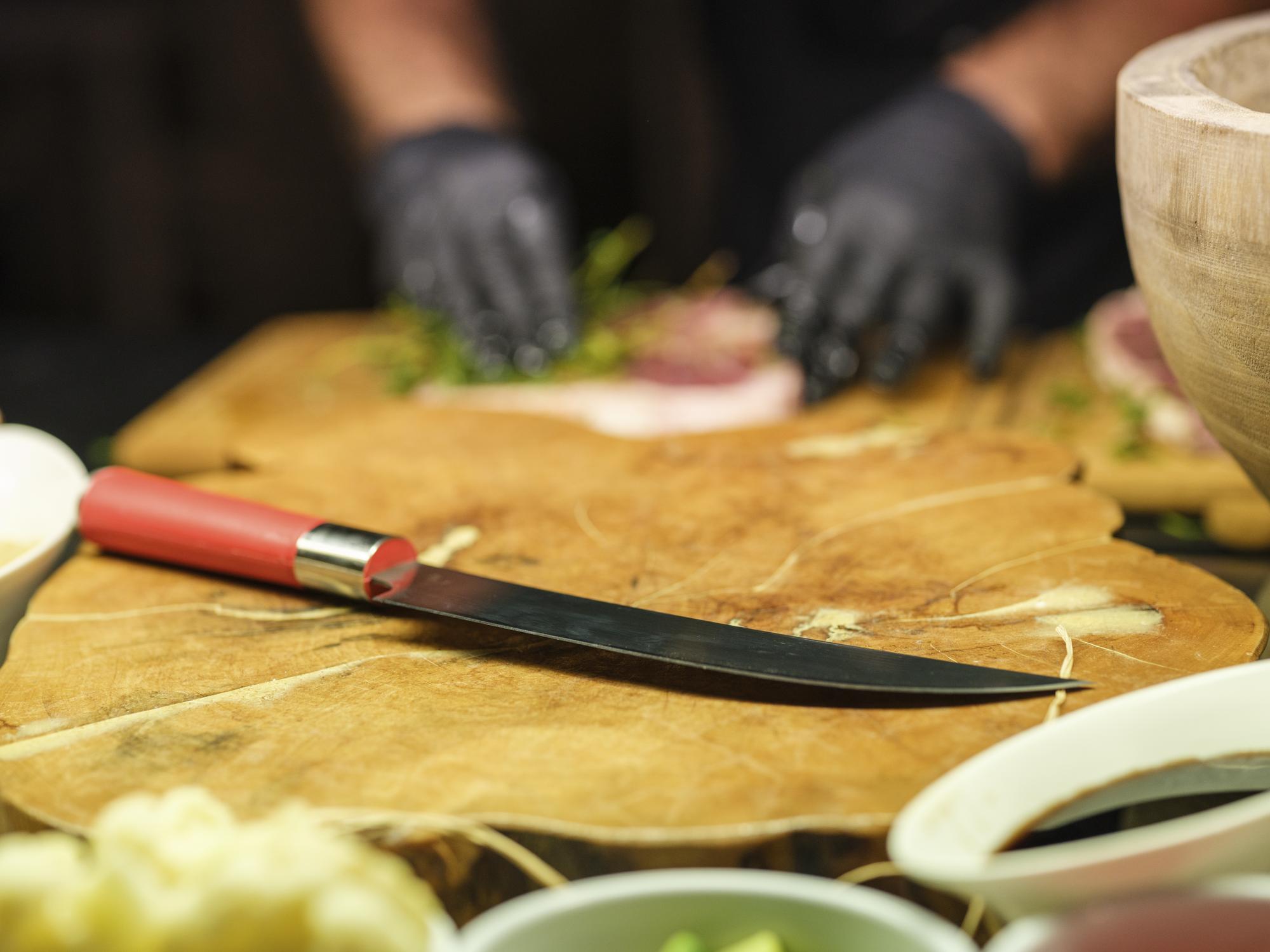 Students practicing knife skills at a counter